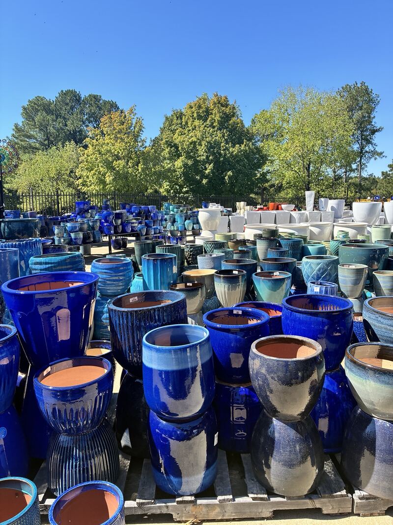 Glazed pots in blue, green, and neutral shades outdoors.