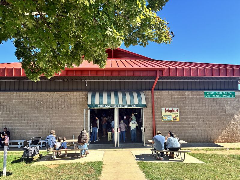 A storefront with a red roof and striped awning.