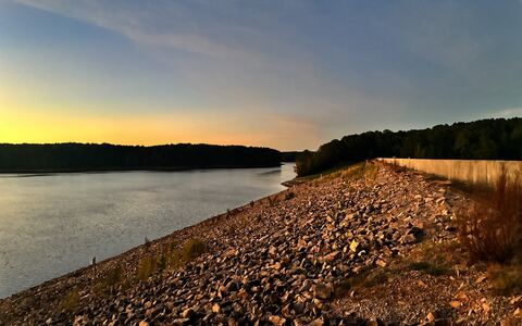 Sunset over Falls Lake and the dam’s rocky embankment