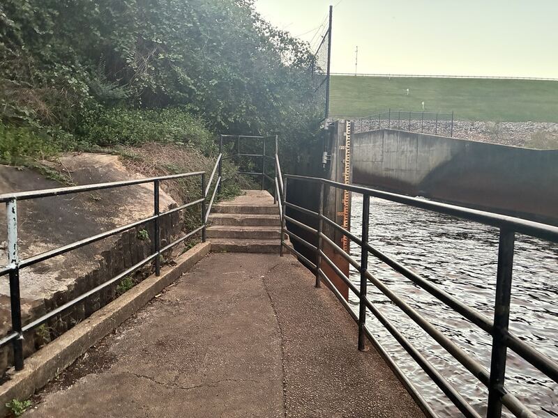 Railings follow the water near the dam.